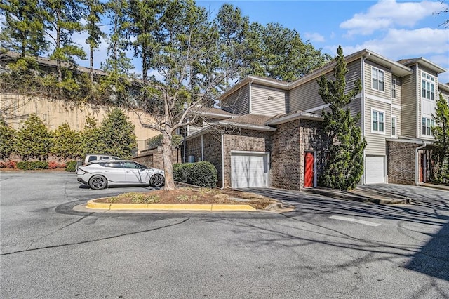 multi unit property featuring brick siding and a garage