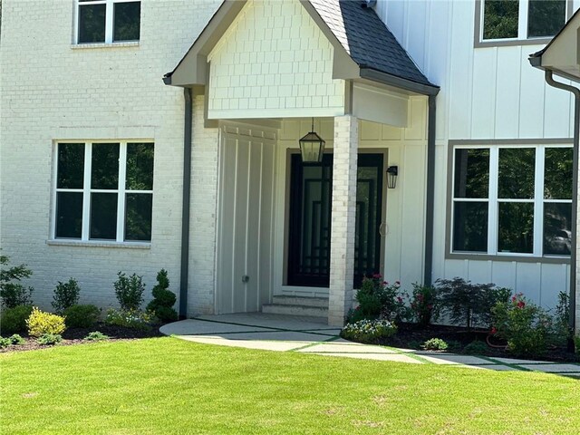 view of exterior entry featuring a yard