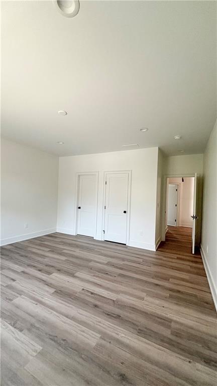 unfurnished room with wood finished floors and baseboards