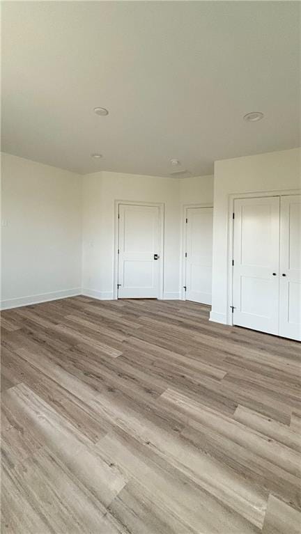 empty room with light wood-style flooring and baseboards