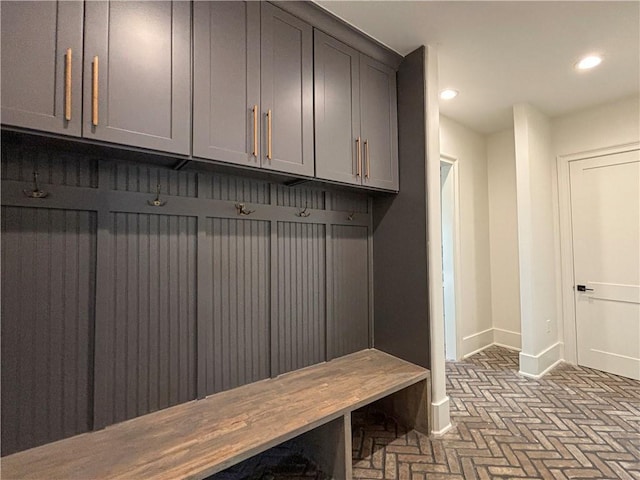 mudroom featuring recessed lighting, baseboards, and brick floor