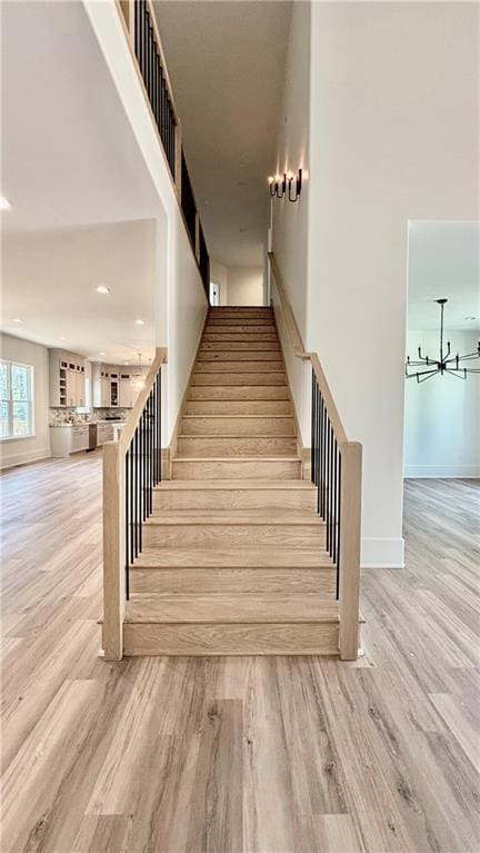 stairs featuring recessed lighting, baseboards, and wood finished floors