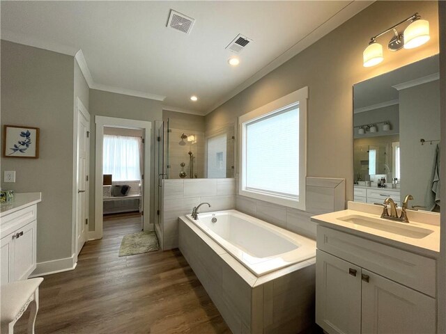 bathroom with independent shower and bath, hardwood / wood-style flooring, vanity, and ornamental molding