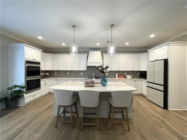 520 Stoneledge Dr, Jasper, GA 30143 - kitchen with custom exhaust hood, stainless steel double oven, black microwave, a center island, and freestanding refrigerator