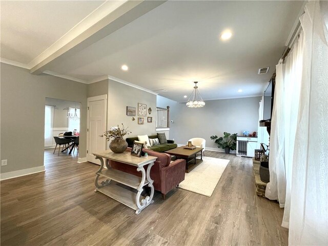 living room with a notable chandelier, crown molding, beamed ceiling, and hardwood / wood-style flooring