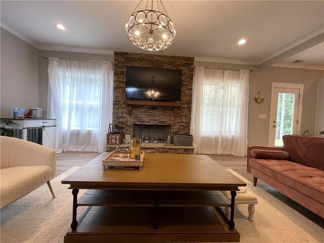 living room with light carpet, a notable chandelier, a fireplace, and ornamental molding