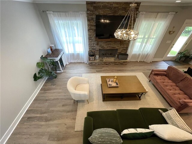 living room featuring hardwood / wood-style flooring, a fireplace, and a chandelier