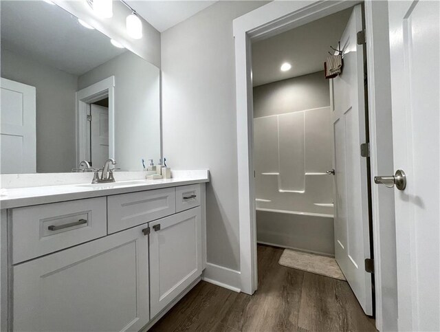 bathroom featuring hardwood / wood-style floors, vanity, and a bathing tub