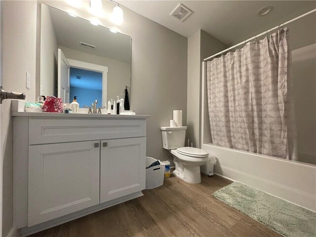 full bathroom with shower / bath combo, vanity, toilet, and wood-type flooring