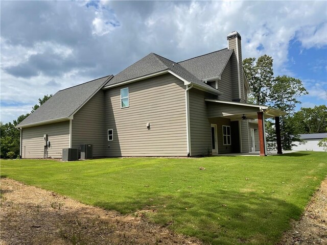 view of property exterior featuring a lawn, ceiling fan, and central AC