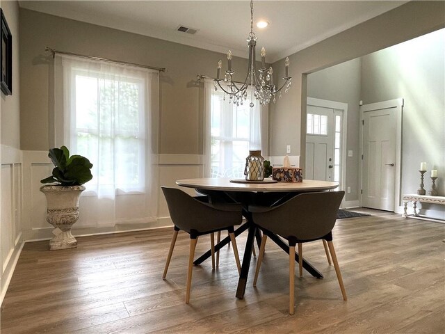 dining space featuring wood-type flooring and a chandelier