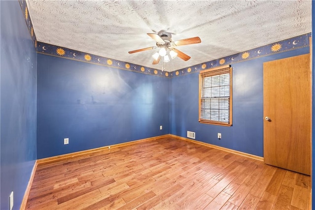 unfurnished room with a textured ceiling, ceiling fan, and wood-type flooring