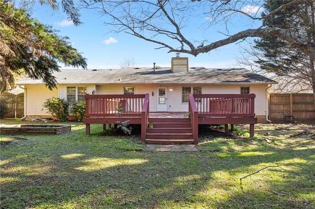 rear view of house featuring a lawn and a wooden deck