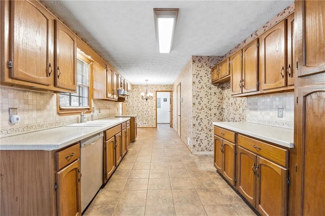 kitchen with decorative backsplash, dishwasher, hanging light fixtures, and sink