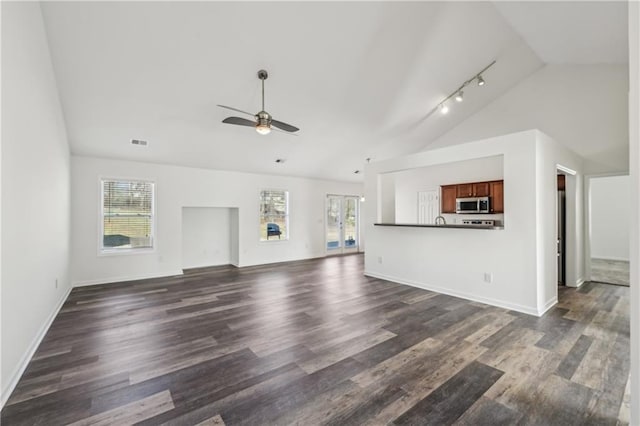 unfurnished living room featuring a wealth of natural light, visible vents, vaulted ceiling, and ceiling fan