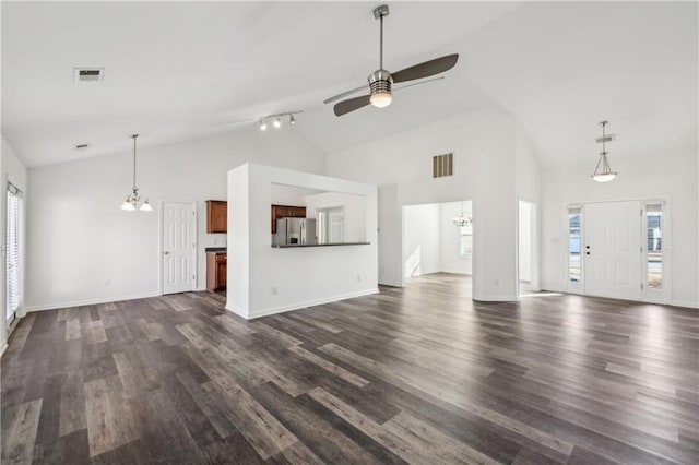 unfurnished living room with dark wood-style flooring, visible vents, and ceiling fan with notable chandelier