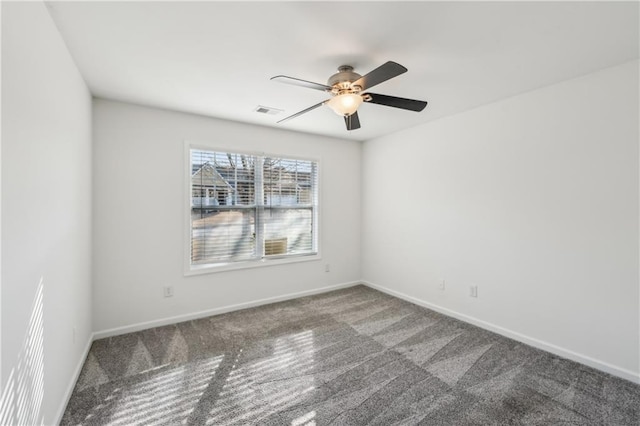 spare room featuring carpet flooring, ceiling fan, visible vents, and baseboards