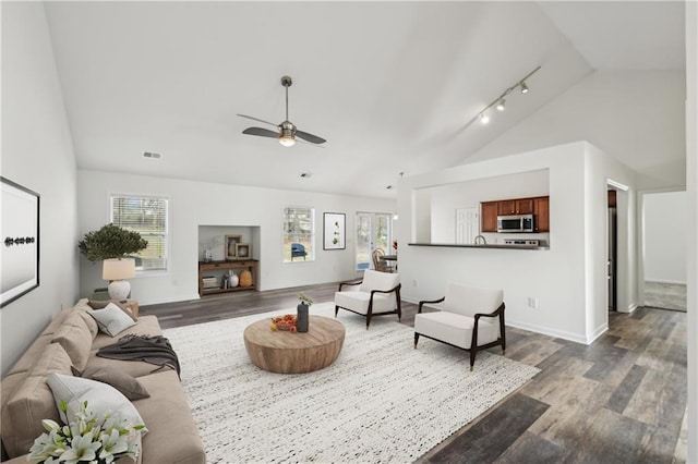 living area with visible vents, a ceiling fan, vaulted ceiling, dark wood-style floors, and rail lighting