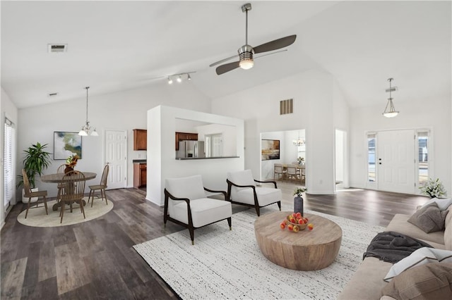 living area featuring ceiling fan with notable chandelier, high vaulted ceiling, dark wood finished floors, and visible vents