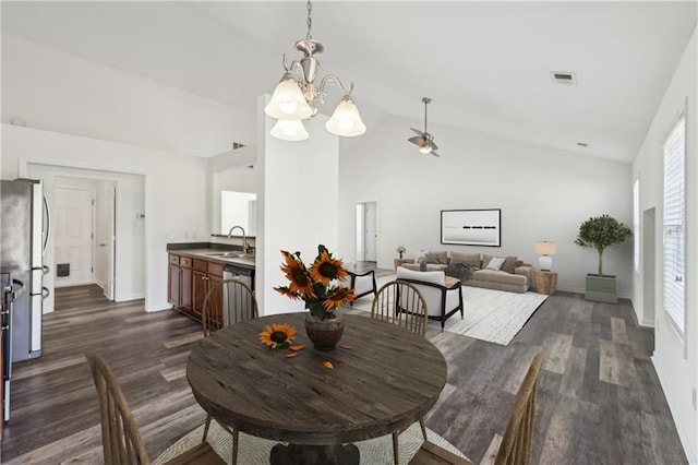 dining space featuring dark wood-style floors, a notable chandelier, visible vents, high vaulted ceiling, and baseboards