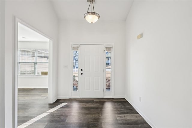 foyer entrance with dark wood finished floors and baseboards