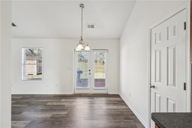 unfurnished dining area featuring lofted ceiling, visible vents, a chandelier, and dark wood-style flooring