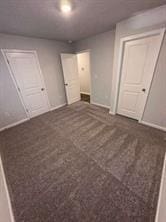 unfurnished bedroom with dark colored carpet