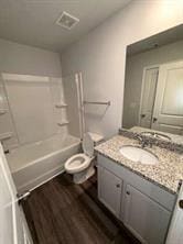 full bathroom with shower / bathtub combination, wood-type flooring, toilet, and vanity