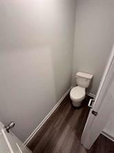 bathroom featuring wood-type flooring and toilet