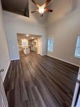 unfurnished living room with ceiling fan and dark hardwood / wood-style floors