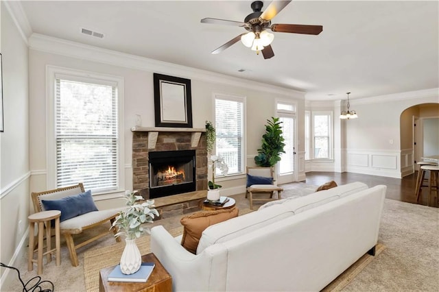 4249 Caveat Ct, Fairburn, GA 30213 - living room with a fireplace, crown molding, a ceiling fan, arched walkways, and a wainscoted wall
