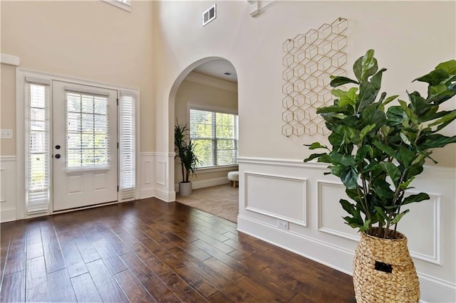 4249 Caveat Ct, Fairburn, GA 30213 - foyer entrance with arched walkways, a decorative wall, a wainscoted wall, and dark wood-style flooring