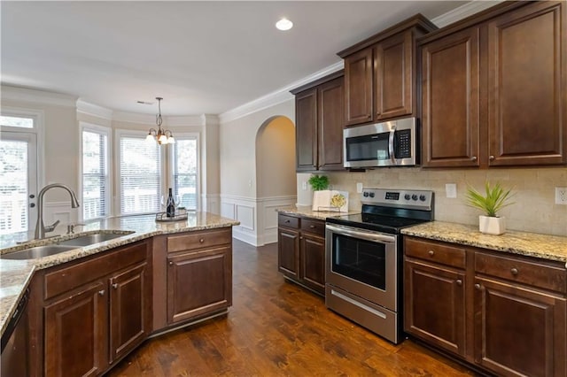 4249 Caveat Ct, Fairburn, GA 30213 - kitchen with stainless steel appliances, arched walkways, ornamental molding, light stone countertops, and a decorative wall