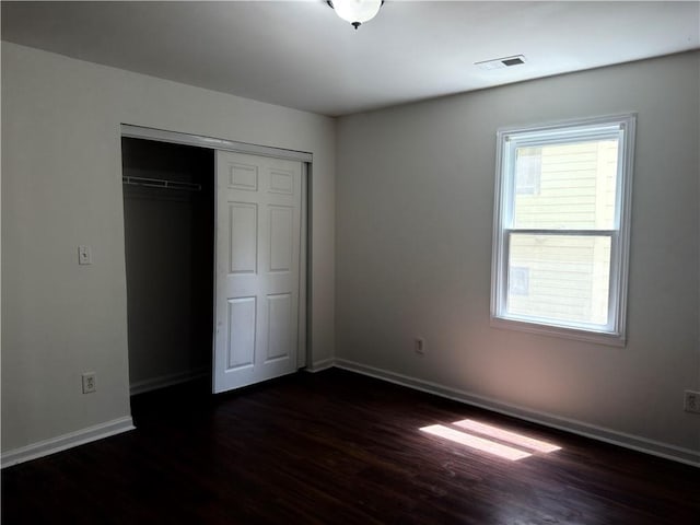 210 Ormond St SW, Atlanta, GA 30315 - unfurnished bedroom featuring dark wood-style floors, baseboards, and a closet