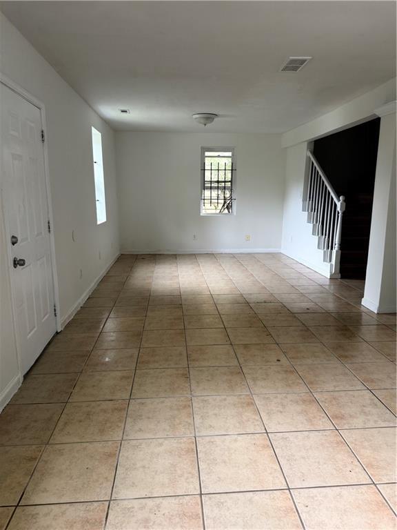 210 Ormond St SW, Atlanta, GA 30315 - unfurnished room featuring stairs, light tile patterned flooring, and baseboards