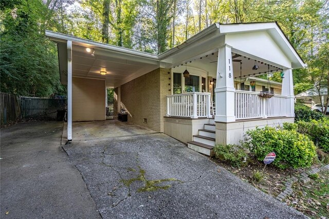 single story home featuring a front yard, a carport, and a porch