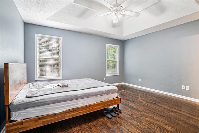 bedroom featuring wood finished floors, baseboards, and a ceiling fan