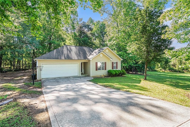 single story home featuring driveway, a garage, a front yard, and view of wooded area