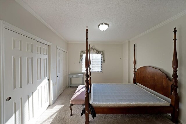 1800 Clairmont Lk Unit 326, Decatur, GA 30033 - bedroom with light colored carpet, a textured ceiling, crown molding, and multiple closets