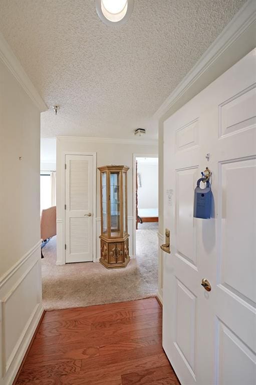 1800 Clairmont Lk Unit 326, Decatur, GA 30033 - corridor with a wainscoted wall, a textured ceiling, wood finished floors, crown molding, and a decorative wall