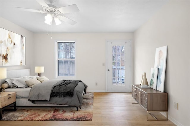 bedroom featuring light wood-type flooring, access to exterior, ceiling fan, and baseboards