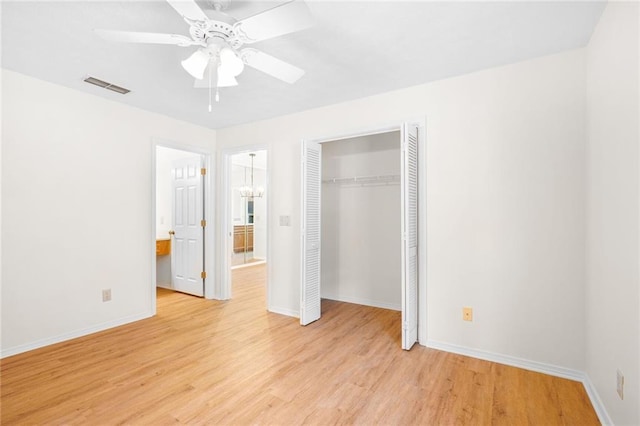 unfurnished bedroom featuring light wood finished floors, baseboards, visible vents, ensuite bath, and a closet