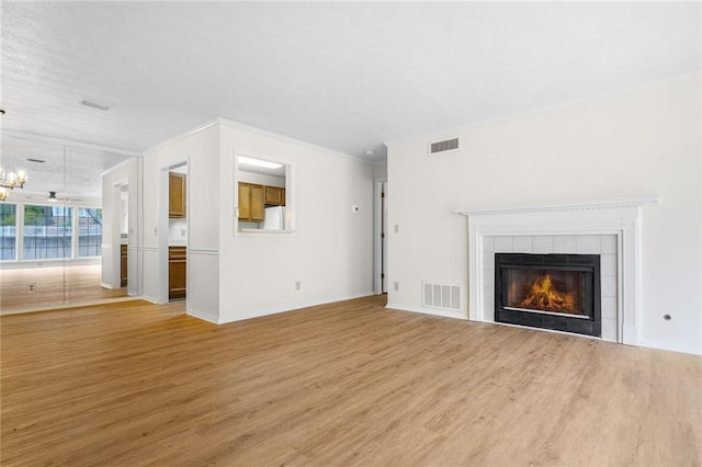 unfurnished living room with light wood-style floors, a fireplace, and visible vents