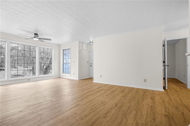 unfurnished living room with a ceiling fan, light wood-style flooring, baseboards, and crown molding