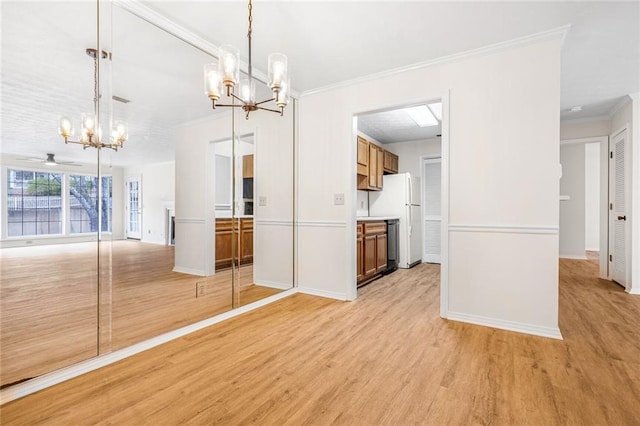 interior space with hanging light fixtures, light wood finished floors, ornamental molding, and open floor plan