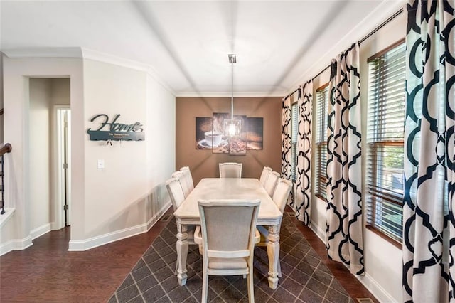 dining area featuring dark hardwood / wood-style floors, an inviting chandelier, and crown molding