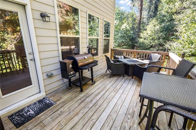 wooden deck with area for grilling and an outdoor fire pit