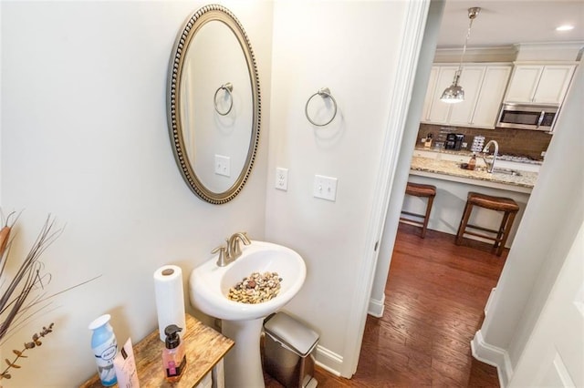 bathroom with tasteful backsplash, sink, and wood-type flooring