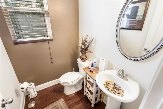 bathroom featuring wood-type flooring, toilet, and sink