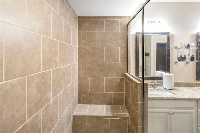 bathroom featuring vanity, walk in shower, and tile walls